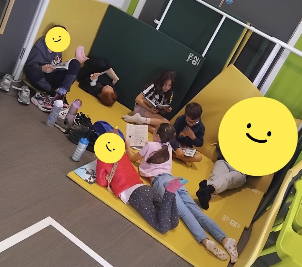 Children relaxing with books during holiday club free choice time.